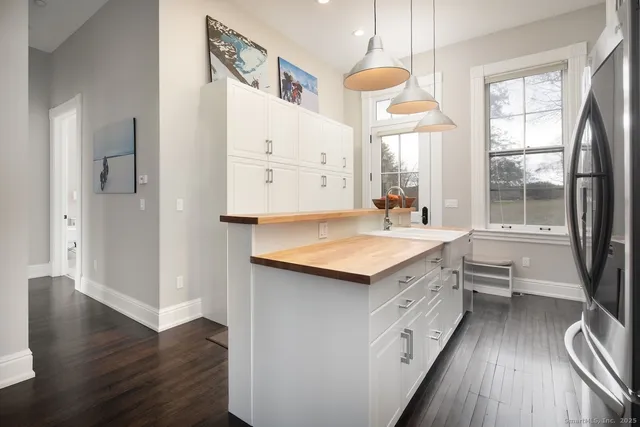 a kitchen with a sink stove and wooden floor