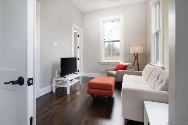 a living room with furniture a flat screen tv and a window
