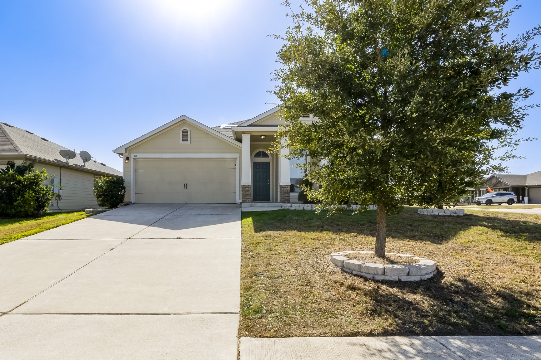 View of front of property with driveway, a front lawn, a garage, and stone siding
