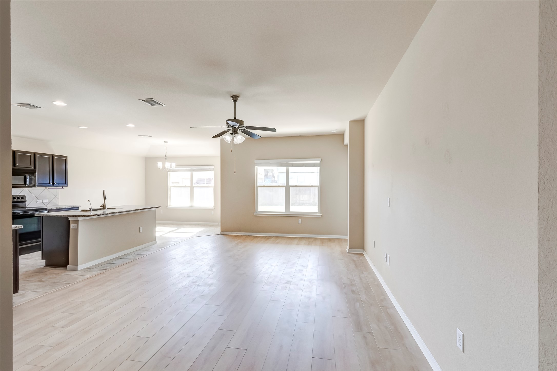 100 Sulphur River Loop Hutto, TX 78634 - Photo 5 of 16 Unfurnished living room with light wood-style floors, a chandelier, ceiling fan, and recessed lighting