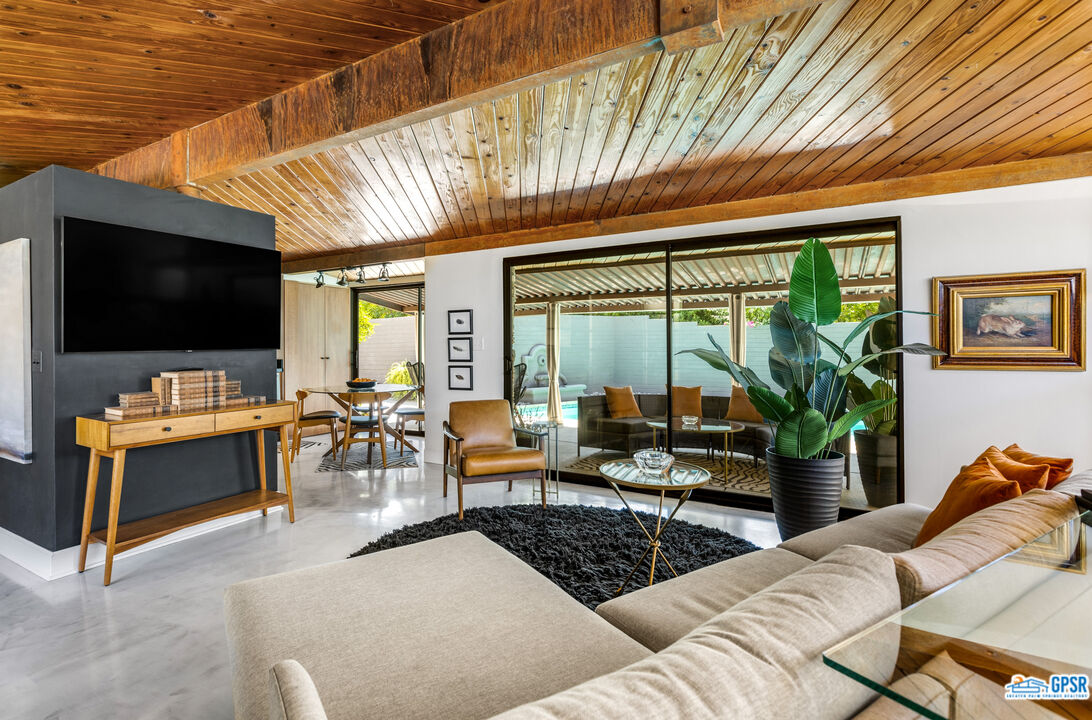 45666 Shadow Mountain Drive Palm Desert, CA 92260 - Photo 13 of 73 a living room with furniture a flat screen tv and floor to ceiling window
