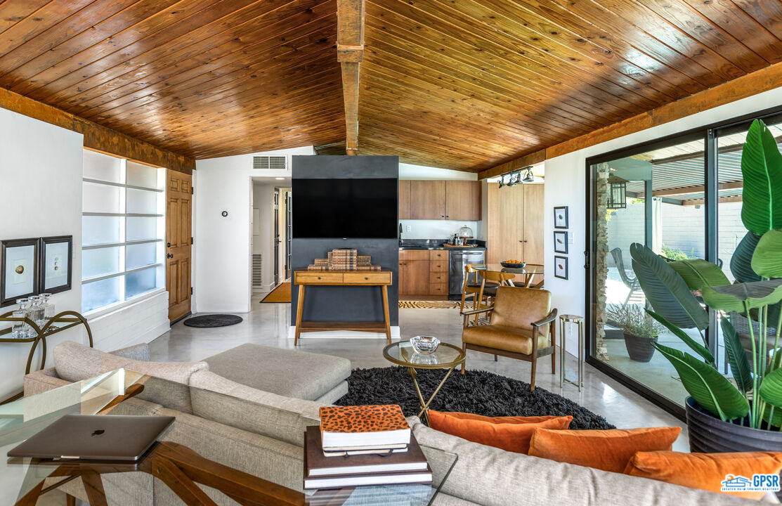 45666 Shadow Mountain Drive Palm Desert, CA 92260 - Photo 15 of 73 a living room with furniture a flat screen tv and floor to ceiling window