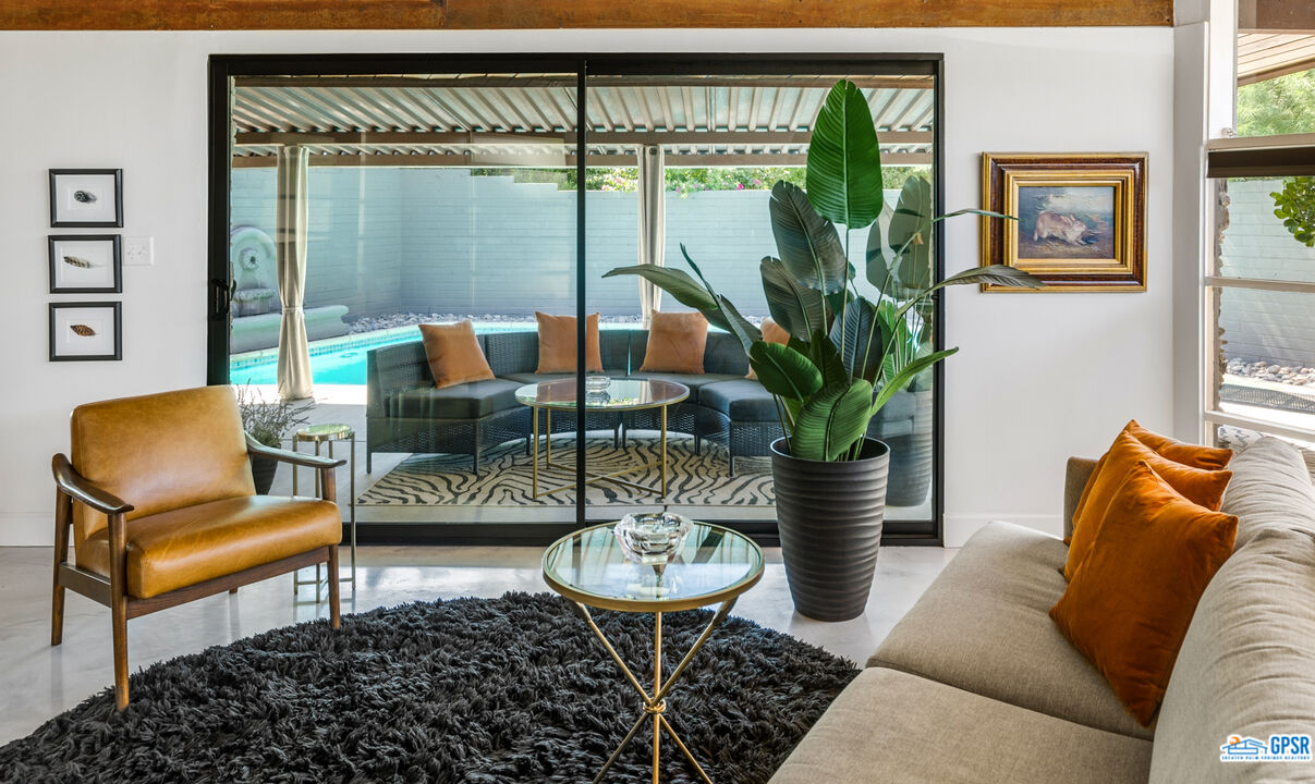 45666 Shadow Mountain Drive Palm Desert, CA 92260 - Photo 16 of 73 a living room with furniture potted plant and a large window