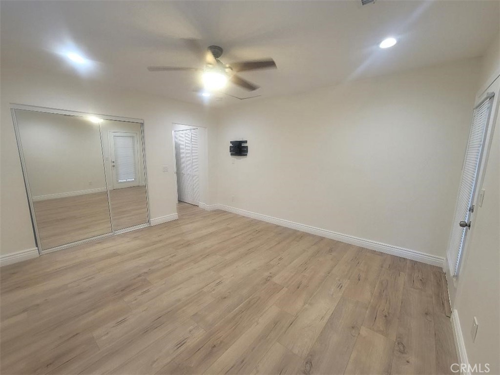 8907 Boyar Avenue Whittier, CA 90605 - Photo 11 of 16 an empty room with wooden floor and mirror