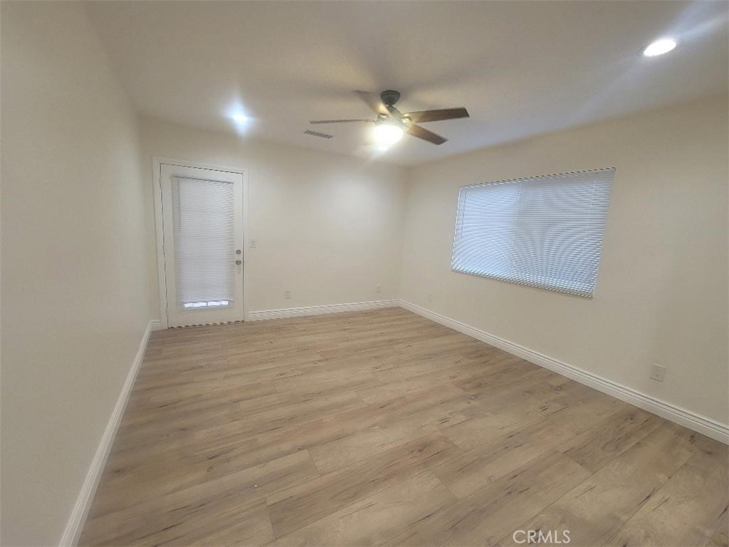 8907 Boyar Avenue Whittier, CA 90605 - Photo 12 of 16 an empty room with wooden floor ceiling fan and windows