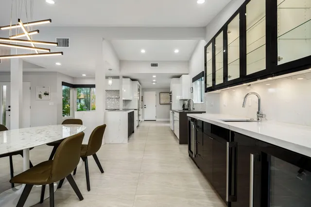 a kitchen with kitchen island white cabinets and refrigerator