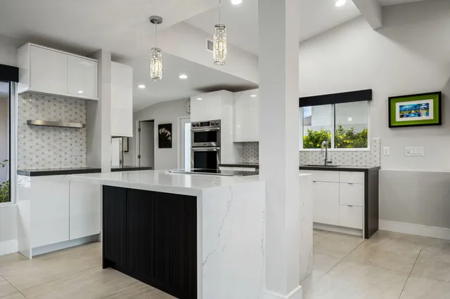 a kitchen with kitchen island granite countertop a sink appliances and a counter top space