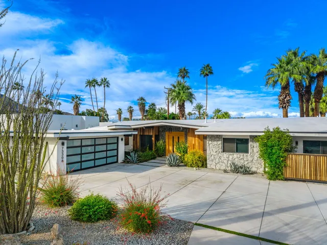 a view of a house with swimming pool and next to a yard