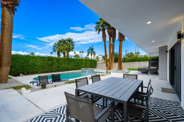 a view of a patio with couple of chairs and potted plants