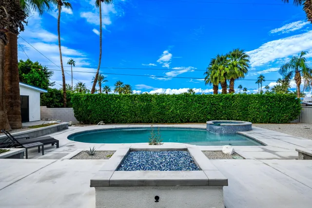a view of house with swimming pool and sitting area
