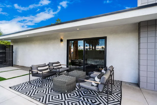 a view of a house with a large window and potted plants