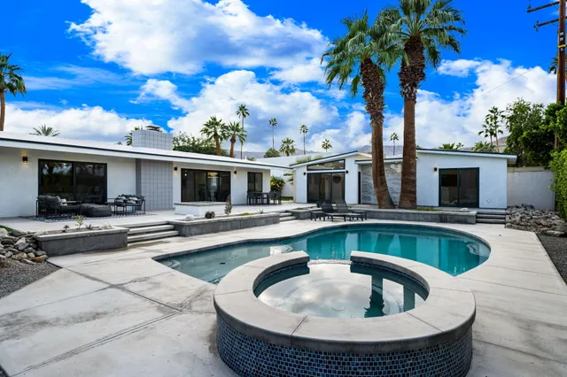 a hallway with stainless steel appliances granite countertop a refrigerator and a sink