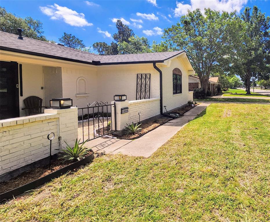 2908 Washington Street Commerce, TX 75428 - Photo 3 of 29 White brick facade with black trim accents and a black composite shingle roof