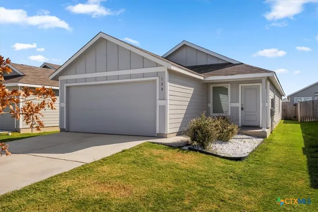 a front view of house with yard and garage