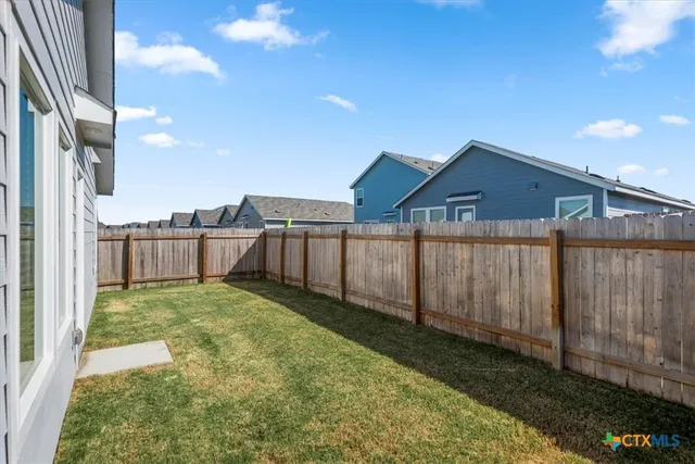 a view of a backyard with wooden fence