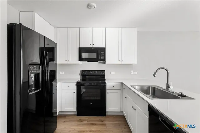 a kitchen with stainless steel appliances a refrigerator sink and cabinets