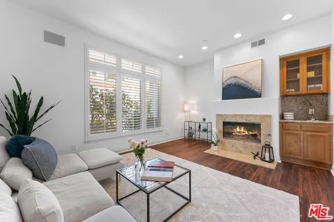 a living room with furniture fireplace and a large window
