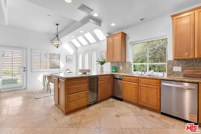 a kitchen with kitchen island granite countertop a stove a sink a dining table and chairs