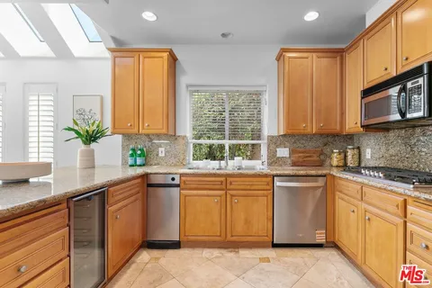 a kitchen with cabinets appliances a sink and a window