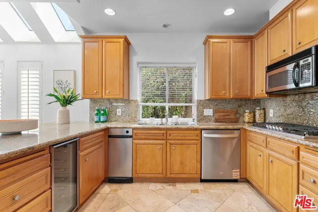 a kitchen with cabinets appliances a sink and a window