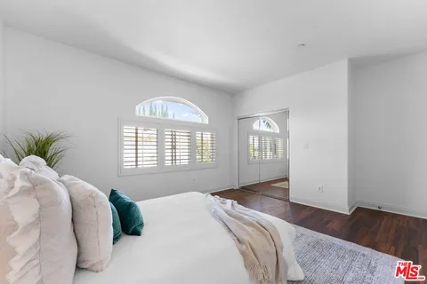 a bedroom with a bed and a large window