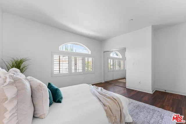 a bedroom with a bed and a large window