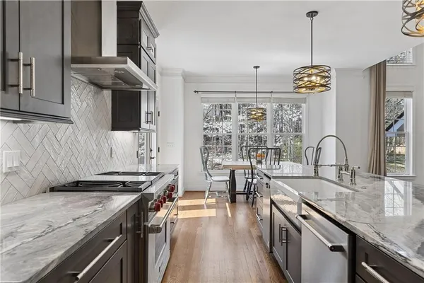 a kitchen with kitchen island granite countertop lots of counter top space a sink and appliances