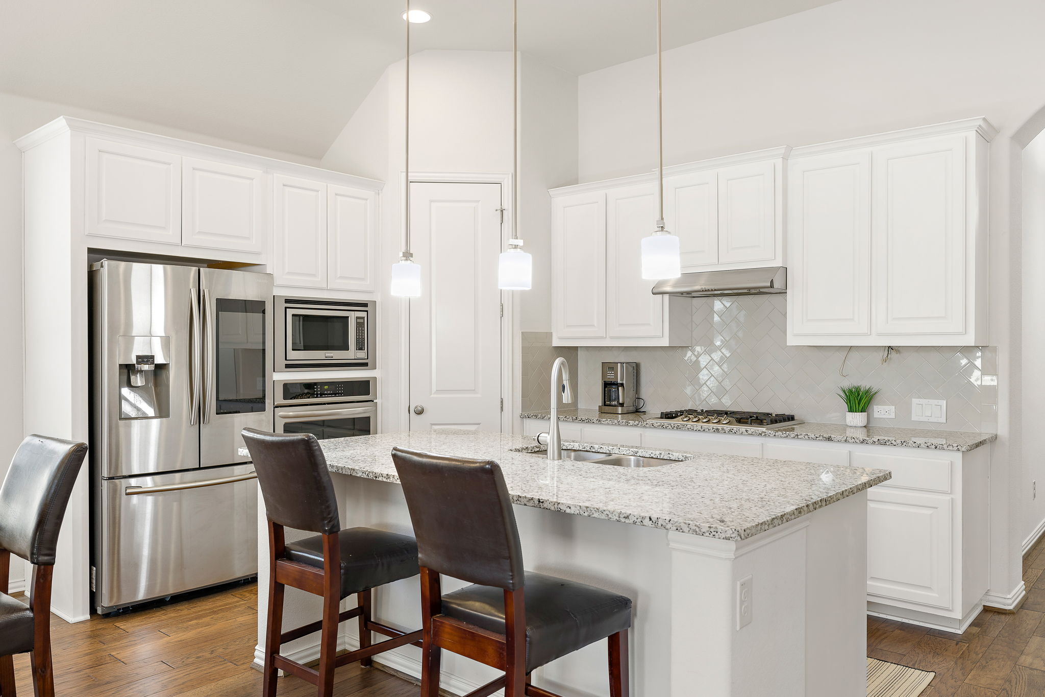 4201 Vespa Cove Leander, TX 78641 - Photo 5 of 29 a kitchen with stainless steel appliances kitchen island granite countertop a kitchen island hardwood floor and a sink