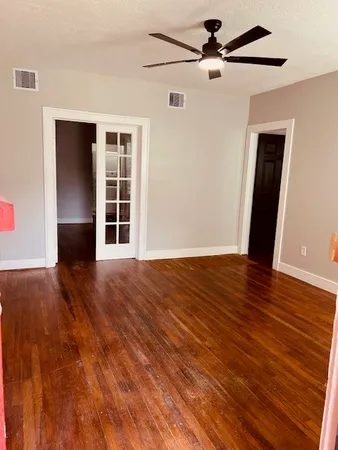 a view of empty room with wooden floor