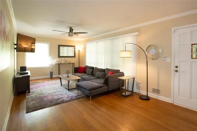 a living room with furniture and a wooden floor