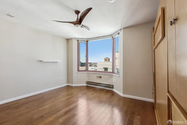 a view of a hallway with wooden floor and a bathroom