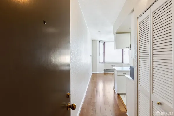 a view of a kitchen with wooden floor and a window