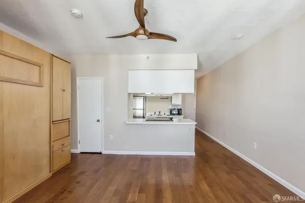 a kitchen with stainless steel appliances a stove refrigerator and wooden floor