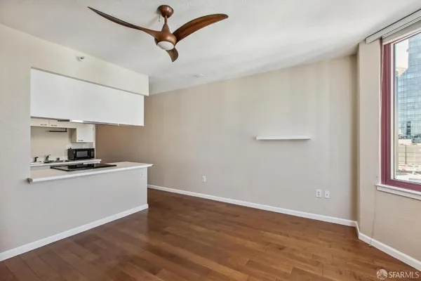 a kitchen with stainless steel appliances a sink dishwasher a refrigerator a stove and white cabinets with wooden floor