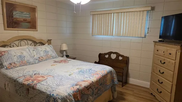 a bedroom with a bed and a flat tv screen on dresser