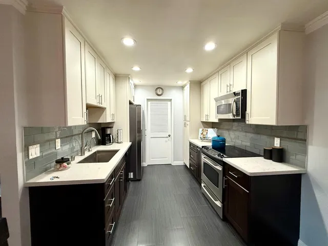 a kitchen with a sink appliances and cabinets