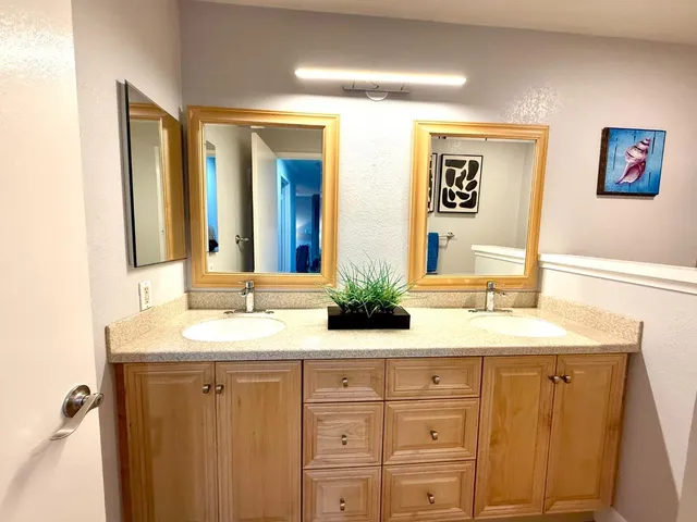 a bathroom with a granite countertop sink a mirror and bathtub