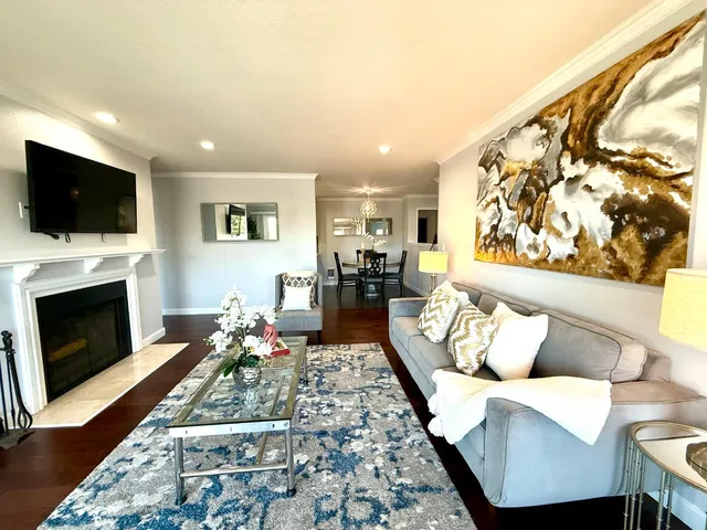 a living room with furniture a flat screen tv and a fireplace