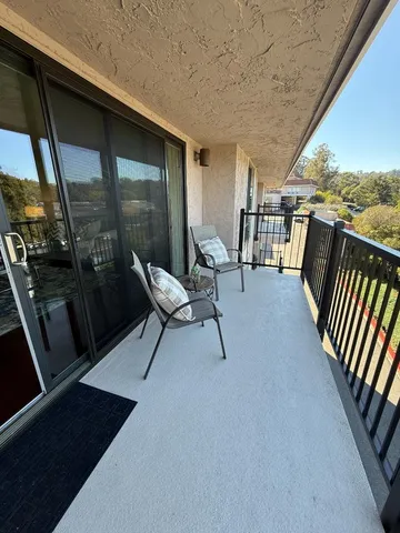 a view of a chairs and table in the balcony