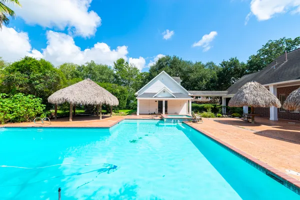 a view of an house with swimming pool and yard