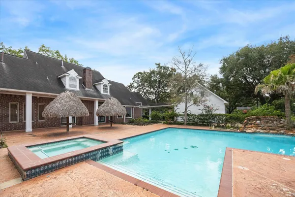 an aerial view of a house with swimming pool and deck