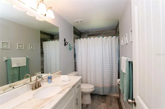 a bathroom with a sink vanity mirror and toilet