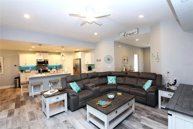 a living room with furniture kitchen view and a chandelier