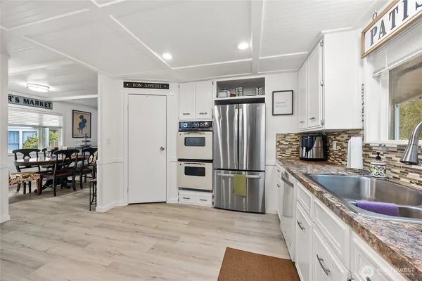 a kitchen with stainless steel appliances granite countertop a refrigerator and a stove top oven