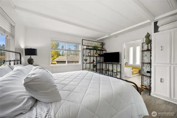 a bed sitting in a bedroom and a flat screen tv