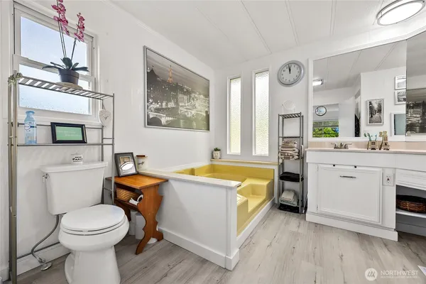 a bathroom with a granite countertop toilet sink and mirror