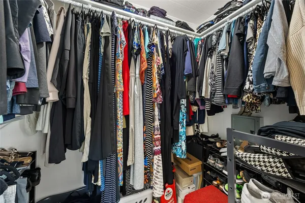 a view of walk in closet with clothes and shoes