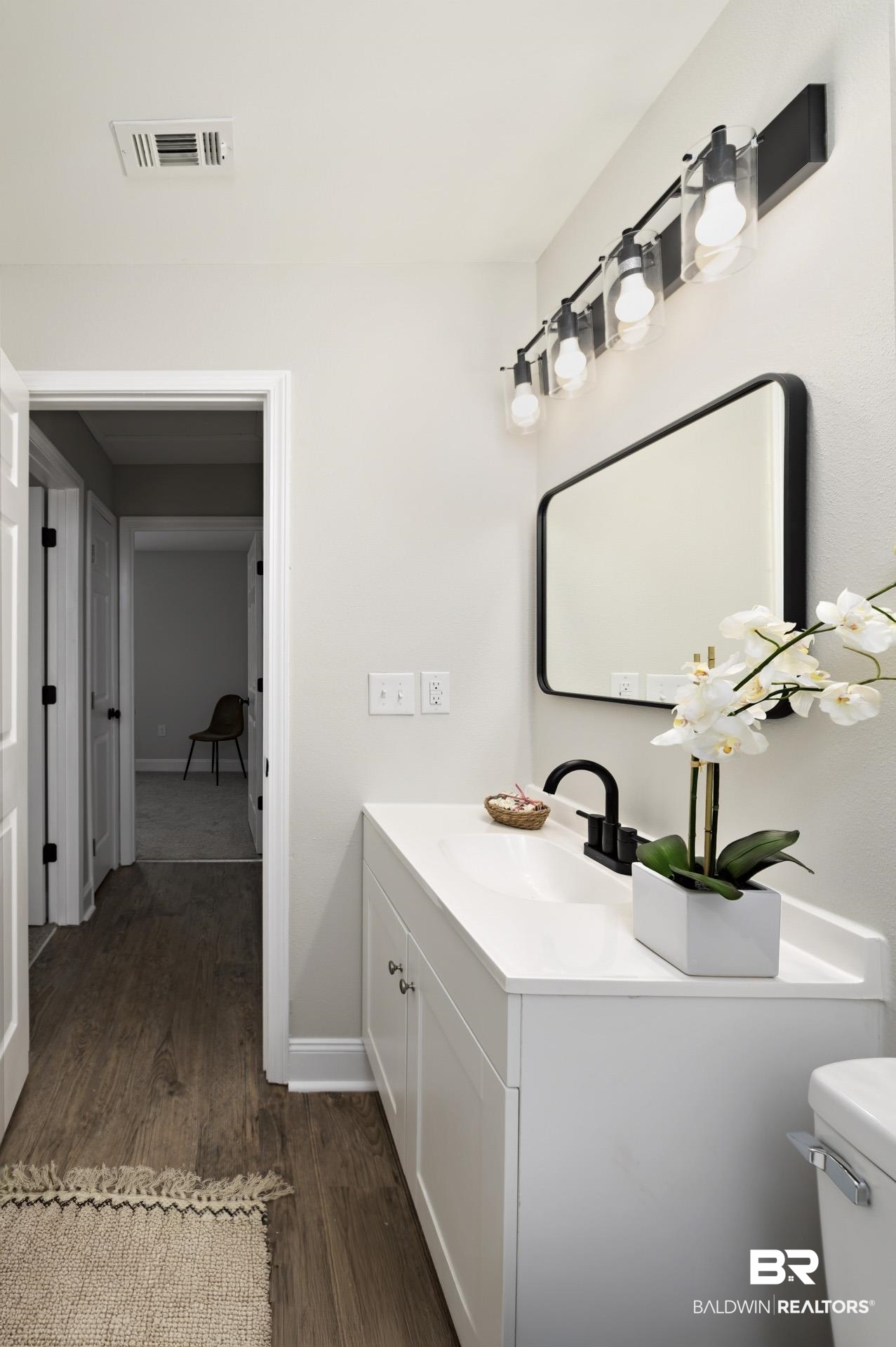 21717 Shadowbrook Street Robertsdale, AL 36567 - Photo 16 of 32 Half bath featuring visible vents, toilet, vanity, wood finished floors, and baseboards