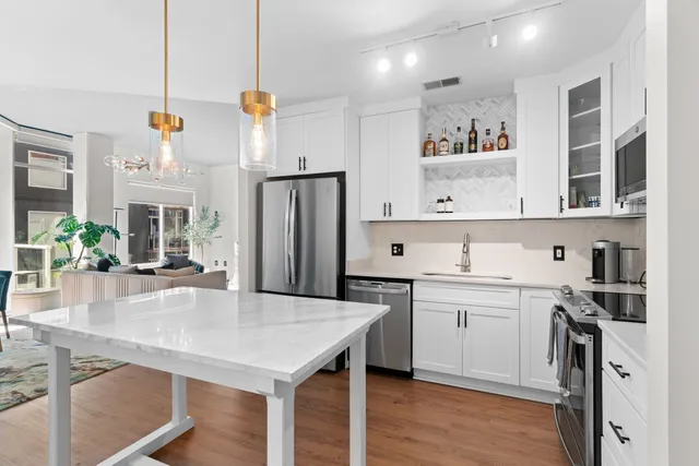 a kitchen with stainless steel appliances granite countertop a sink refrigerator and cabinets