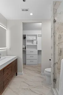 a bathroom with a granite countertop sink toilet and shower